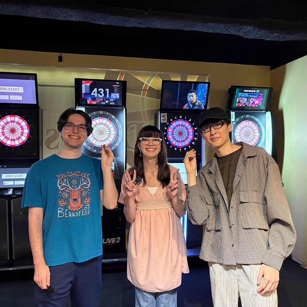 three of us holding darts